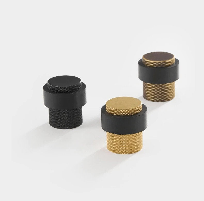 Gold, bronze, and black knurled brass door stops