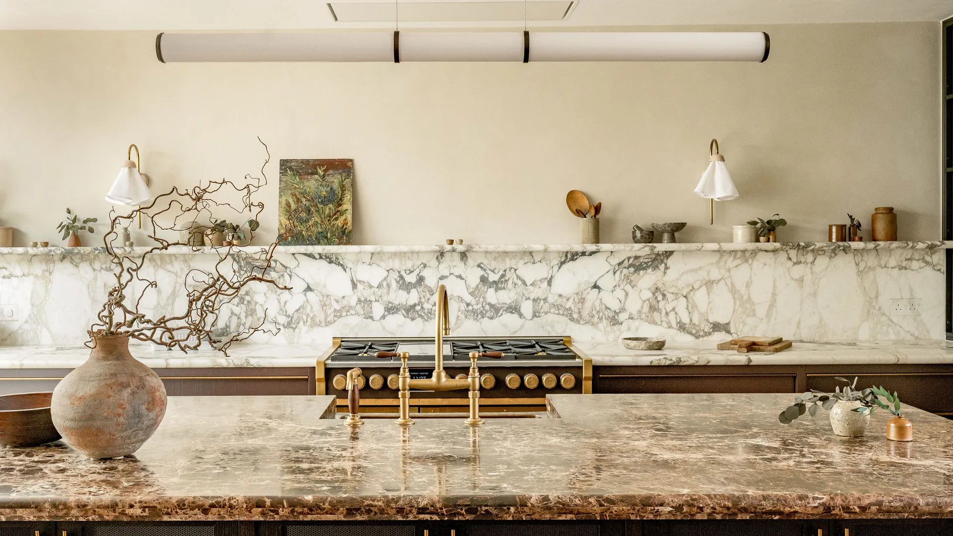 A luxury kitchen with a marble kitchen island and worksurface. 