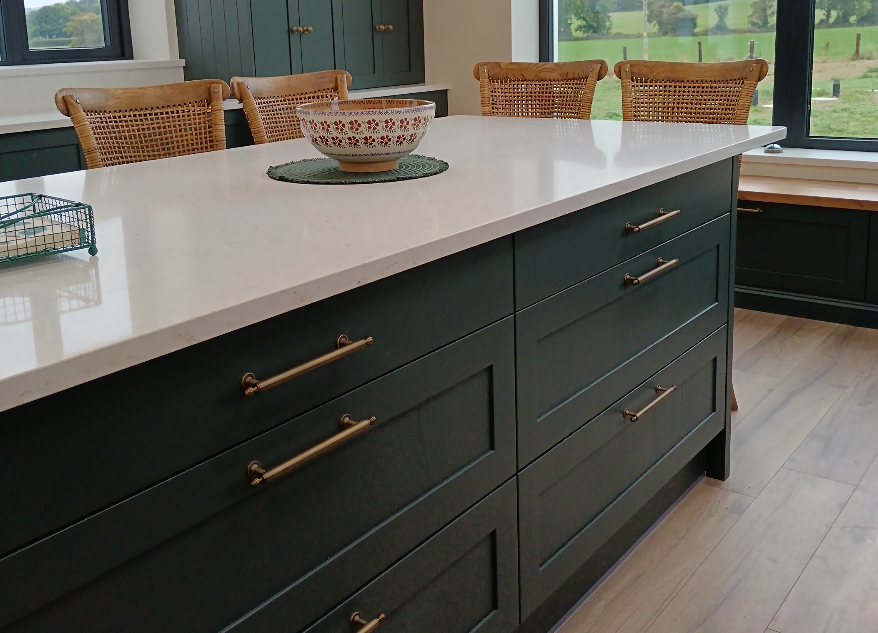 A green kitchen with large glass window. 