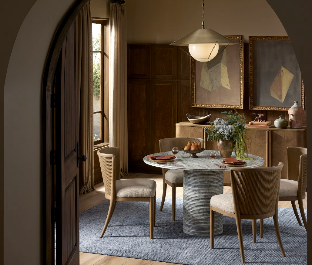 A dining room with a circular dining table and four dining chairs. 