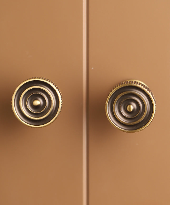 A pair of traditional bronze ornate cabinet door handles. 